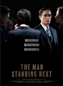 THE MAN STANDING NEXT